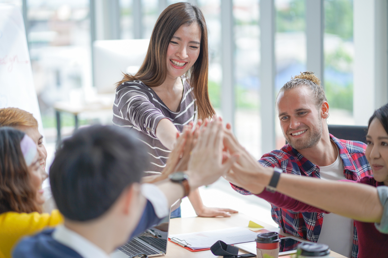 High-five for success creative meeting team at modern